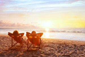 couple relaxing on beach at sunset